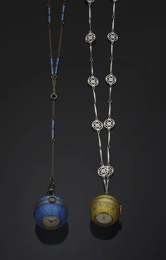SET OF 2 BALL PENDANT WATCHES A)ANONYMOUS SWISS BALL WATCH SILVER AND ENAMEL Anonymous, Swiss. Made circa 1930. Fine, sterling silver and enamel Art Deco ball-shaped pendant watch with a 40 cm sterling silver chain with 11 blue enameled sections. B)BUCHERER BALL WATCH SILVER AND ENAMEL Bucherer, Swiss. Made circa 1930. Fine, sterling silver and enamel Art Deco ball-shaped pendant watch with a 32 cm sterling silver chain with 18 floral décor round stations and 34 baton sections.