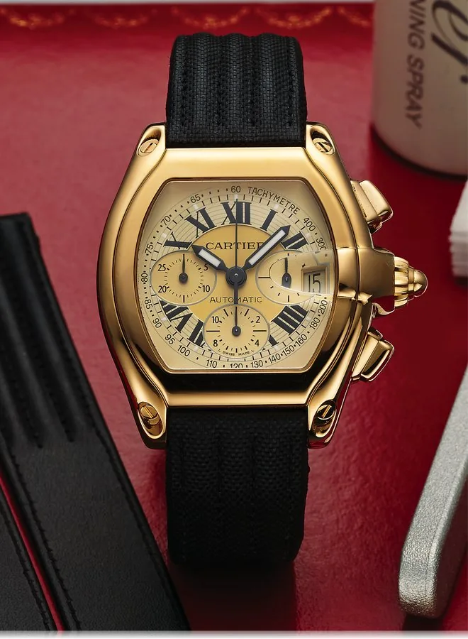 CARTIER REF. 2619 ROADSTER AUTOMATIC CHRONOGRAPH YELLOW GOLD Cartier, "Roadster Chronograph, Automatic," case No. 108851 LX, Ref. 2619. Sold October 3rd, 2000. Fine, large, tonneau-shaped, curved, self-winding, water resistant to 100 m, 18K yellow gold wristwatch with square button chronograph, registers, date, tachometer and an 18K yellow gold Cartier deployant clasp. Accompanied by the box, cleaning utensil, leather pouch and one spare strap.