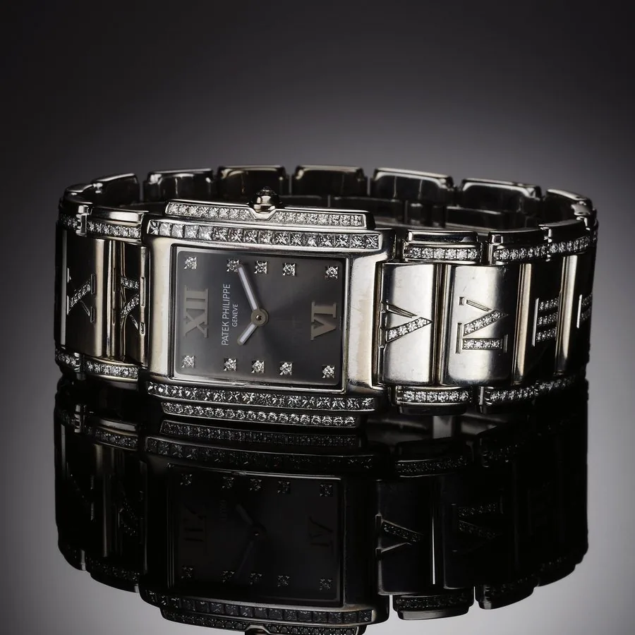 PATEK PHILIPPE REF. 4910 TWENTY FOUR LADY'S QUARTZ DIAMOND AND WHITE GOLD Patek Philippe, Genève, No. 3300343, case No. 4194454, Ref. 4910/41. Made circa 2002. Fine, rectangular curved, water-resistant, 18K white gold and diamond lady's quartz wristwatch with an 18K white gold integral link bracelet with double deployant clasp, links set with a total of 160 round white diamonds, 10 links centered by diamond-set Roman numerals. Accompanied by an Extract from the Archives.