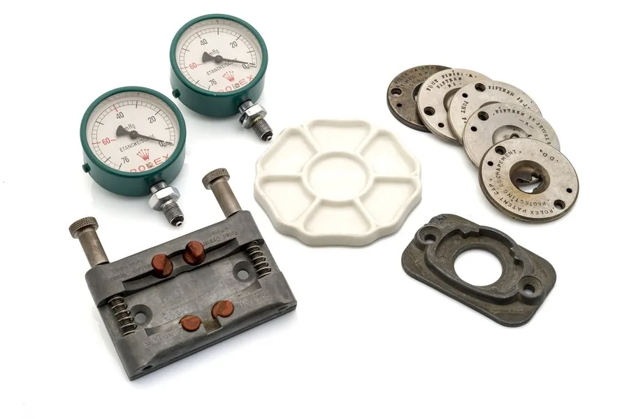 ROLEX, A SET OF RARE ROLEX ITEMS Comprised of rare Rolex movement part making plates (x5), Rolex Oyster Universal Tool, porcelain parts tray, Rolex gauges for the Rolex waterproof tester. In very good overall condition AA.