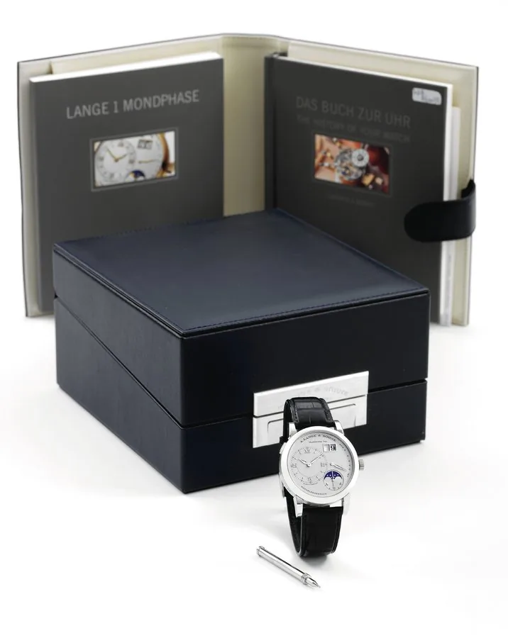 Platinum Lange 1 Moonphase A. Lange & Söhne, Glashütte i. Sa., "Lange 1 Moonphase," No. 47136, case No. 157176, Ref. 109.025. Made in 2003. Production of this reference started in 2002. Very fine, water-resistant, platinum wristwatch with off-center hour dial, oversized date, power-reserve indication, moon phase, and a platinum A. Lange & Söhne buckle. Accompanied by the original fitted box, certificate, booklet, instruction manual and setting pin.