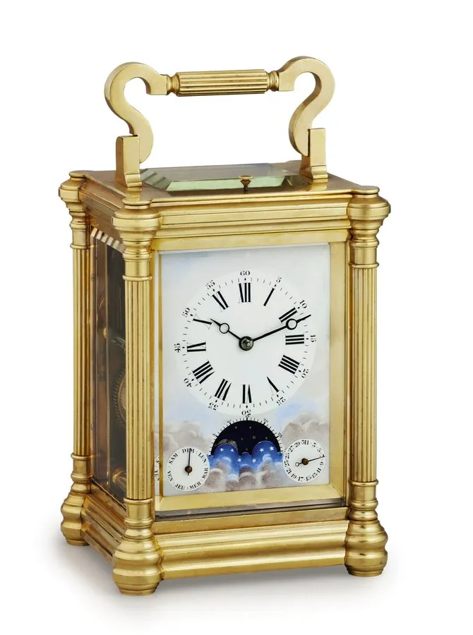 CARRIAGE CLOCK WITH CALENDAR & MOON PHASES Attributed to Jacot, French. Made circa 1880. Extremely fine and rare, large, gilt brass, 8-day going, hour and half-hour striking and repeating carriage clock with alarm, day-date calendar, moon phases and moon's age.