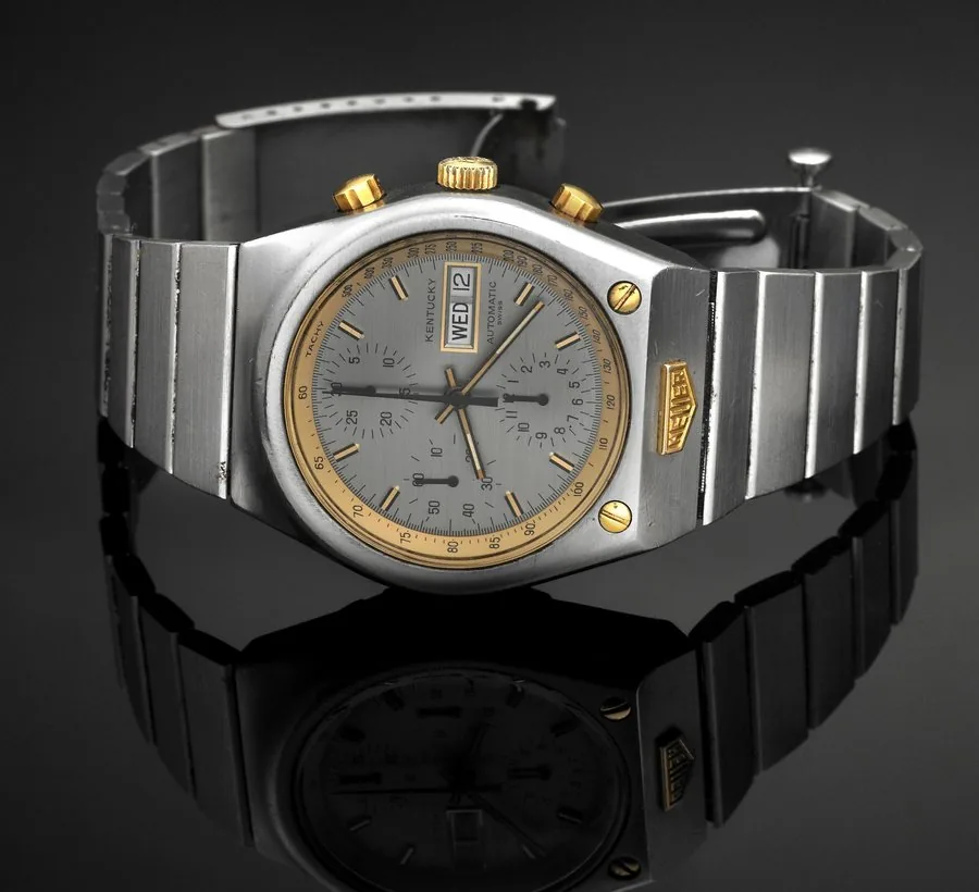 HEUER REF. 750.705 KENTUCKY AUTOMATIC CHRONOGRAPH DAY/DATE Heuer, Kentucky, Automatic, case No. 364543, Ref. 750.705. Made circa 1977. Fine, tonneau shaped, water resistant, self-winding, stainless steel and yellow gold wristwatch, round button chronograph, registers, day & date, tachometer and a stainless steel Heuer link bracelet with deployant clasp. To be sold without reserve