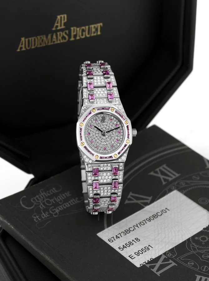 AUDEMARS PIGUET ROYAL OAK, WHITE GOLD LADY'S PINK SAPPHIRE AND DIAMOND Audemars Piguet, Genève, "Royal Oak", No. 629, No. 545818 case No. E90591. Made in 2004. Fine, octagonal, 18K white gold, pink sapphire and diamond-set lady's quartz wristwatch with date with an Audemars Piguet 18k white gold diamond and pink baguette sapphire bracelet and an 18k white gold deployant clasp. Accompanied by the original fitted box, warranty and instruction booklet and an Audemars Piguet Certificate of Origin.