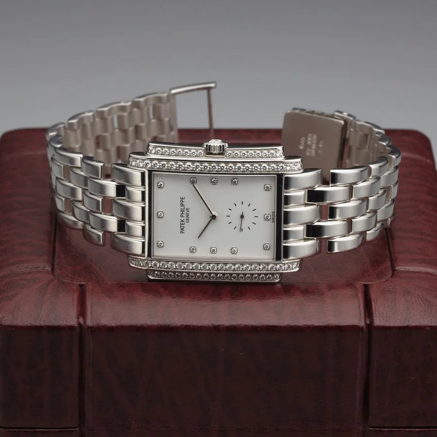 PATEK PHILIPPE REF. 5025 GONDOLO WHITE GOLD & DIAMONDS Patek Philippe, Genève, Gondolo Ref. 5025/1G. Sold May 28th, 2004. Very fine, rectangular curved, water-resistant, 18K white gold and diamonds wristwatch with an integral 18K white gold Patek Philippe link bracelet. Accompanied by a fitted box, copy of Certificate of Origin, 2 extra links, pouch and letter from Patek Philippe, Geneva.