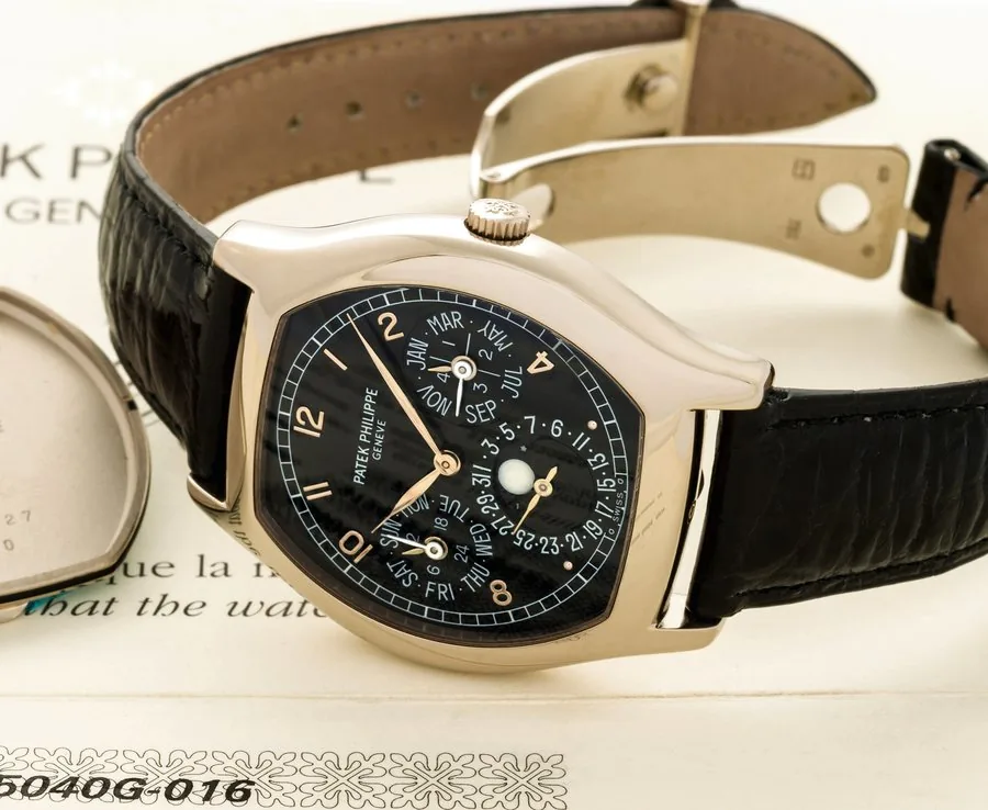PATEK PHILIPPE REF. 5040 WHITE GOLD Patek Philippe, Genève, movement No. 3124121, case No. 4032527, Ref. 5040G. Sold in December 1998. Very fine and rare, tonneau-shaped, astronomic, self-winding, 18K white gold wristwatch with perpetual calendar, moon phases, 24-hour indication and an 18K white gold Patek Philippe deployant buckle. Accompanied by the Certificate of Origin and extra 18k white gold Patek Philippe caseback.
