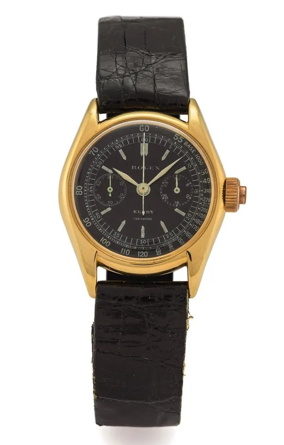 ROLEX, REF. 2303, BABY SINGLE BUTTON CHRONOGRAPH, BLACK DIAL YELLOW GOLD Rolex, case No. 16121, Ref. 2303. Made in 1935, retailed by Kerby. Very fine and extremely rare, small, 18K yellow gold wristwatch with co-axial button chronograph, registers, tachometer, black dial and an 18K yellow gold Rolex buckle.