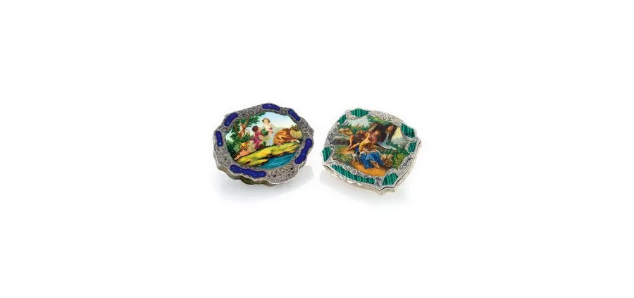 TWO SILVER & ENAMEL LADY'S COMPACTS Continental. Made circa 1935. Two silver and painted on enamel lady's compacts. A) Cartouche-shaped, foliate engraved, fitted interior mirror, the lid decorated with a painted on enamel scene of a young couple in a landscape, enamel border in imitation of hardstone. B) Scalloped, foliate engraved, the interior with a mirror, the lid decorated with a painted on enamel scene of lovers in a landscape.