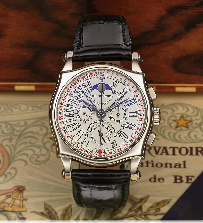 ROGER DUBUIS SYMPATHIE BI-RETRO PERPETUAL CALENDAR CHRONO WHITE GOLD Roger Dubuis, Horloger Genèvois, "Sympathie Bi-Retrograde Perpetual Calendar Chronograph Chronometer," No. 01/28, movement No. 66, Ref. S43 5610 0. Made in a limited edition of 28 pieces. Made in 2002. Very fine, rare and complicated, tonneau-shaped, water-resistant, astronomic, 18K white gold wristwatch with oval button chronograph, register, bi-retrograde perpetual calendar, week of the year indication, moon phases, leap-year