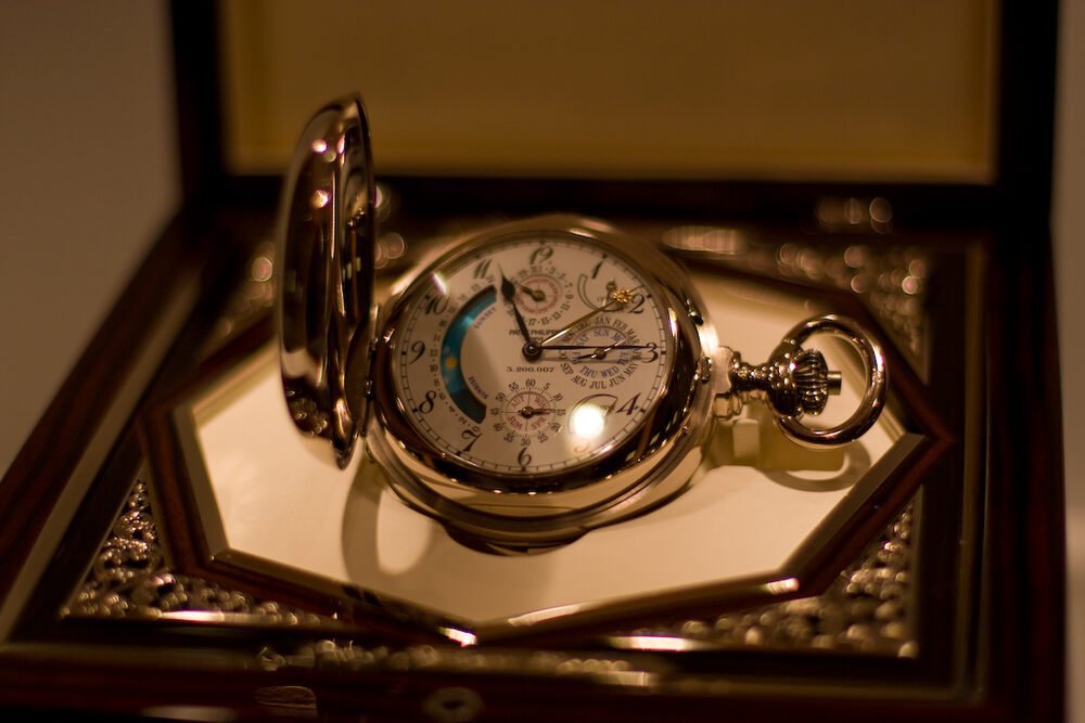 A complicated Patek Philippe pocket watch resting in its fitted presentation box