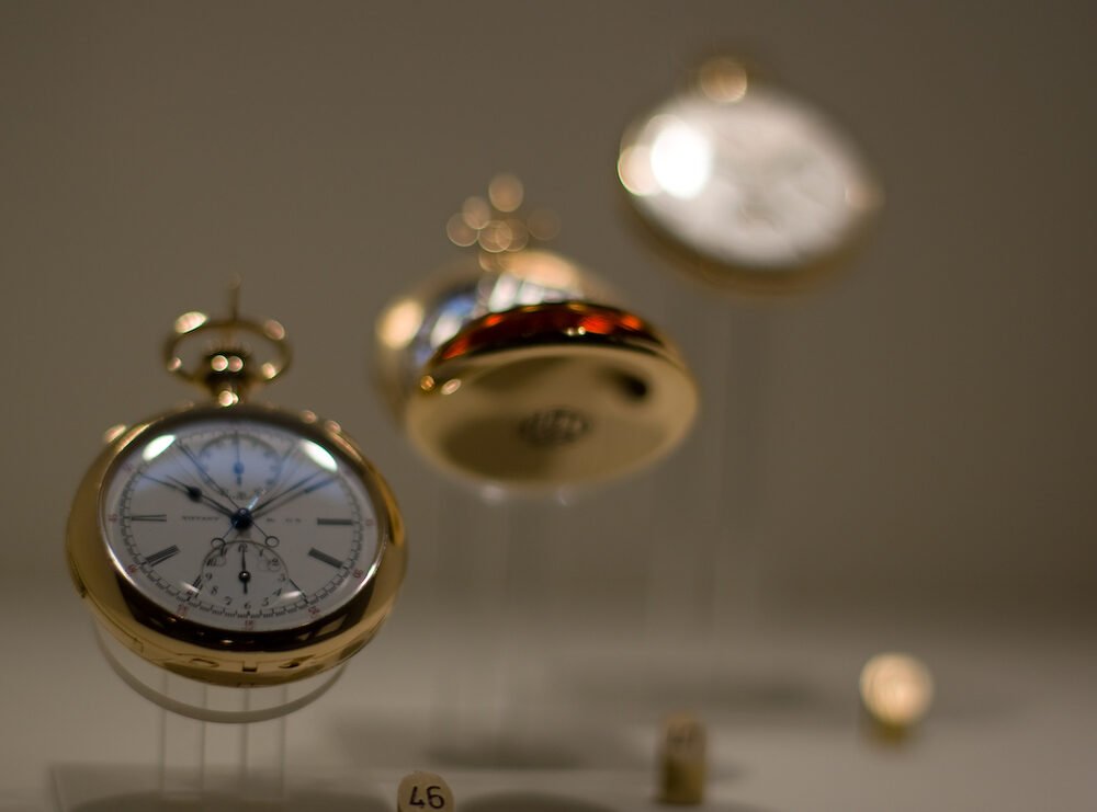 Several antique Patek Philippe pocket watches displayed together on stands