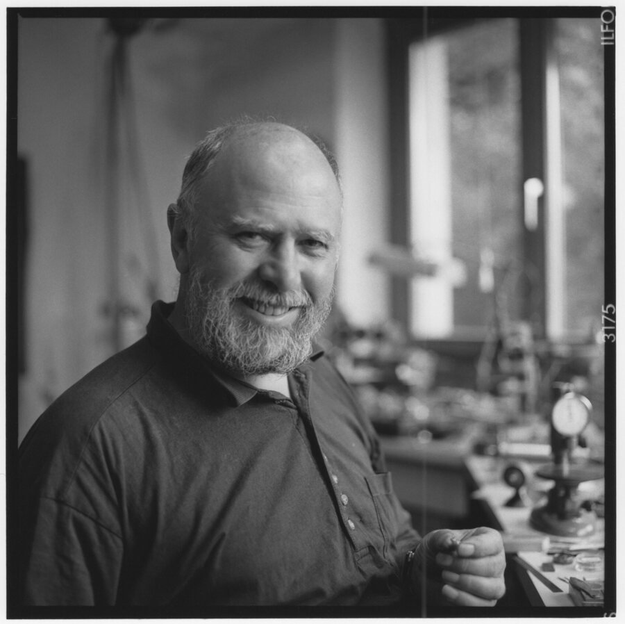 An independent watchmaker at his bench in a Swiss workshop