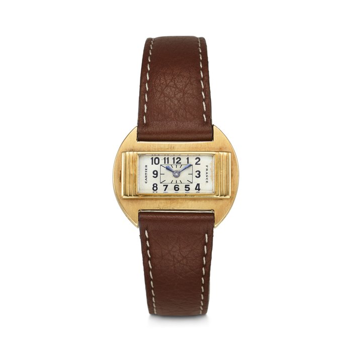 CARTIER. AN EXTREMELY RARE AND UNUSUAL 18K GOLD CUSHION-SHAPED WRISTWATCH WITH ARABIC NUMERAL DIAL SIGNED CARTIER, FRANCE, MOVEMENT SIGNED EUROPEAN WATCH & CLOCK CO. INC., MOVEMENT NO. 246'938, CASE NOS. 25'570, 6877, CLASP NO. 24'772, CIRCA 1931