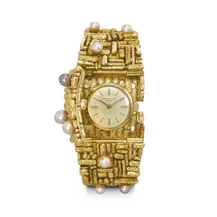 PATEK PHILIPPE. AN IMPRESSIVE, HIGHLY UNUSUAL AND ATTRACTIVE 18K GOLD AND CULTURED PEARL-SET BRACELET WATCH WITH CONCEALED DIAL, DESIGNED BY GILBERT ALBERT REF. 3295, MOVEMENT NO. 857'421, CASE NO. 311'092, MANUFACTURED IN 1961