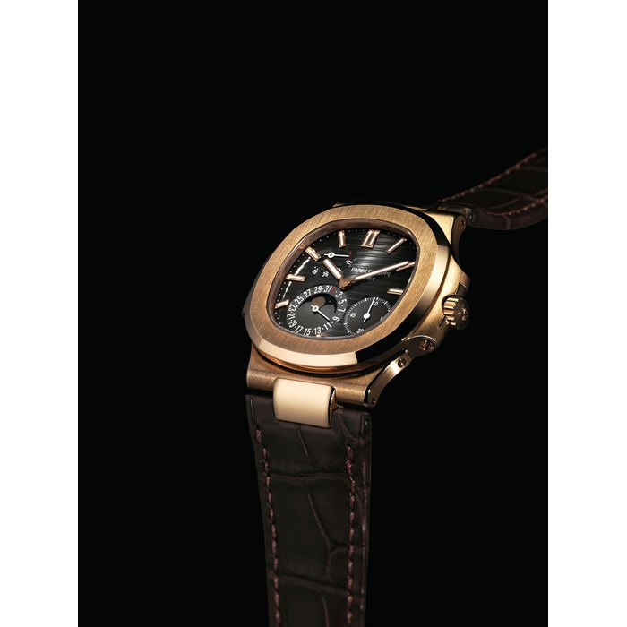 PATEK PHILIPPE. A FINE 18K PINK GOLD AUTOMATIC WRISTWATCH WITH DATE, POWER RESERVE, MOON PHASES, ORIGINAL CERTFICATE AND BOX SIGNED PATEK PHILIPPE, GENEVE, NAUTILUS MODEL, REF. 5712, MOVEMENT NO. 3'177'337, CASE NO. 4'452'868, CIRCA 2008
