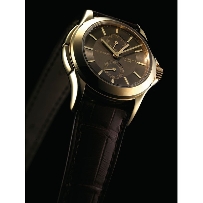 PATEK PHILIPPE. A FINE AND RARE 18K GOLD LIMITED EDITION DUAL TIME WRISTWATCH WITH 24 HOUR INDICATION, ORIGINAL CERTIFICATE AND BOX, MADE TO COMMEMORATE THE 150TH ANNIVERSARY WITH GÜBELIN SIGNED PATEK PHILIPPE, GENEVE, TRAVEL TIME MODEL, REF. 5134, MOVEMENT NO. 3'087'133, CASE NO. 4'224'703, CIRCA 2004