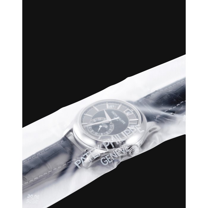 PATEK PHILIPPE. A FINE 18K WHITE GOLD AUTOMATIC ANNUAL CALENDAR WRISTWATCH WITH SWEEP CENTRE SECONDS, MOON PHASES, 24 HOURS INDICATION AND ORIGINAL CERTIFICATE, FACTORY SEALED SIGNED PATEK PHILIPPE, GENEVE, REF. 5205, MOVEMENT NO. 5'556'035, CASE NO. 4'525'786, CIRCA 2011