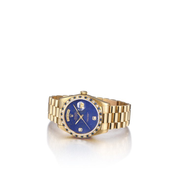 Rolex ROLEX. A FINE AND RARE 18K GOLD, DIAMOND AND SAPPHIRE-SET AUTOMATIC WRISTWATCH WITH SWEEP CENTRE SECONDS, DAY, DATE, BRACELET AND LAPIS LAZULI DIAL SIGNED ROLEX, OYSTER PERPETUAL, DAY-DATE MODEL, REF. 18148/18000, CASE NO. 8'063'782, CIRCA 1983