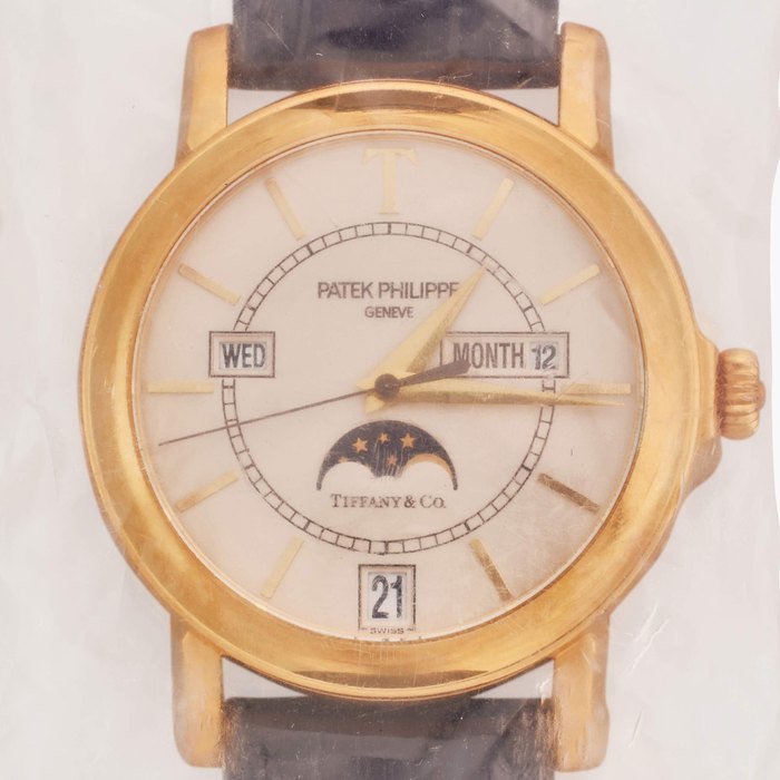Patek Philippe Retailed by Tiffany & Co.: Reference 5150 'T150' | A limited edition yellow gold automatic annual calendar wristwatch with moon phases and engraved case back, Made to commemorate the 150th anniversary of the exceptional relationship between Patek Philippe and Tiffany & Co., Single Sealed, Made in 2001