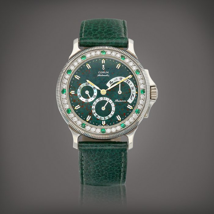 Corum Reference 73.109.79 | A platinum, diamond and emerald-set wristwatch with date, power reserve indication, bloodstone and mother-of-pearl dial, Circa 1995 |  崑崙  | 型號73.109.79  | 鉑金鑲鑽石及綠寶石腕錶，備日期、動力儲備顯示及血石及珠母貝錶盤，約1995年製 · 73.109.79
