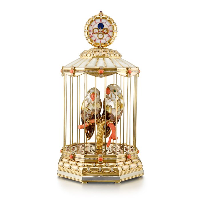 Gérald Genta Reference G3221 A | A yellow gold and gold plated brass, diamond, emerald, pink coral and mother-of-pearl-set perpetual calendar desk clock with singing bird mechanism, day, date and moon phases, Circa 1980 | Gérald Genta | 型號G3221 A |  黃金及鍍金銅製鑲鑽石、綠寶石、粉紅珊瑚及珠母貝萬年曆座鐘，備鳥鳴機關，日期、星期及月相顯示，約1980年製 · G3221