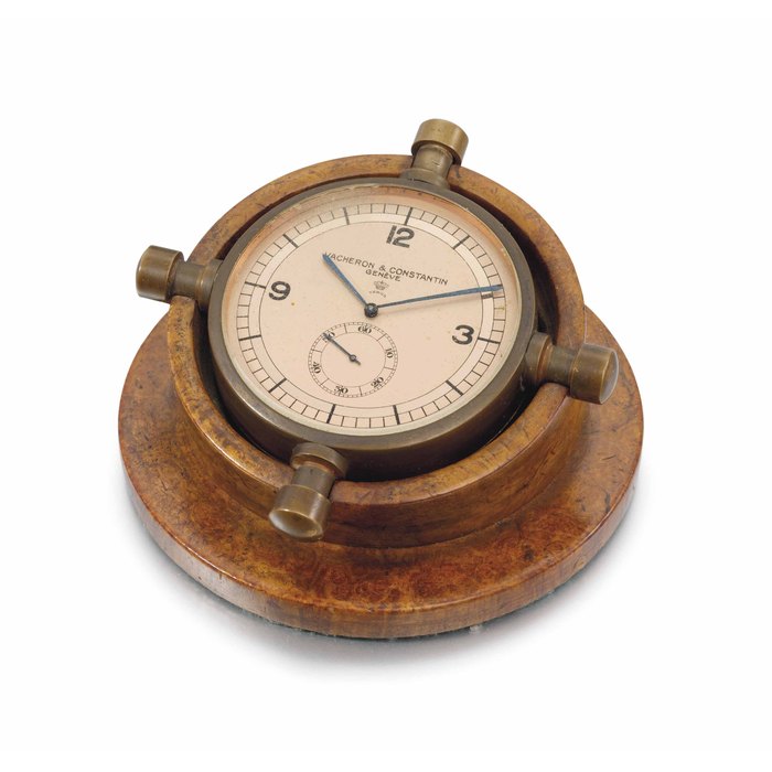 Vacheron Constantin. A rare and unusual copper-coloured brass helm-shaped keyless lever display desk clock with two-tone pink dial and walnut stand SIGNED VACHERON CONSTANTIN, RETAILED BY VERGA, MOVEMENT NO. 371'456, CASE NO. 20, ENCASED AND SOLD IN 1940