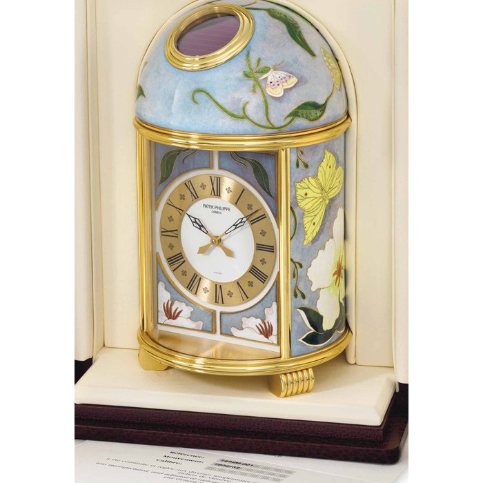 Patek Philippe. A very fine and unique gilt brass solar-powered table clock with cloisonne enamel by L. Rhee, certificate and presentation box SIGNED PATEK PHILIPPE, GENEVE, DOME, "PAPILLONS", MOVEMENT NO. 1'804'752, REF. 1484M-001, MANUFACTURED IN 2006