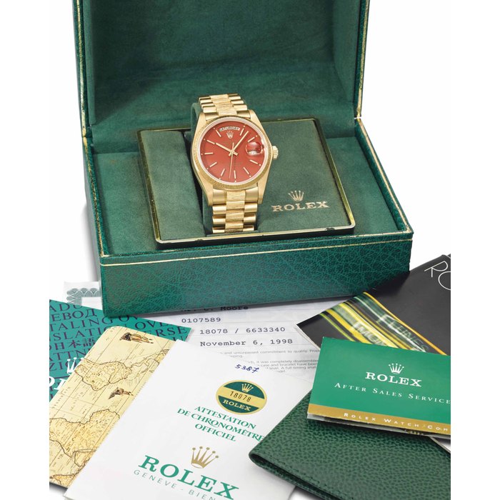 Rolex. A fine, very rare and attractive 18K gold automatic wristwatch with day, date, sweep centre seconds, red lacquer dial, bracelet, Garantie and box SIGNED ROLEX, OYSTER PERPETUAL, DAY-DATE, REF. 18078, CASE NO. 6'633'340, CIRCA 1981