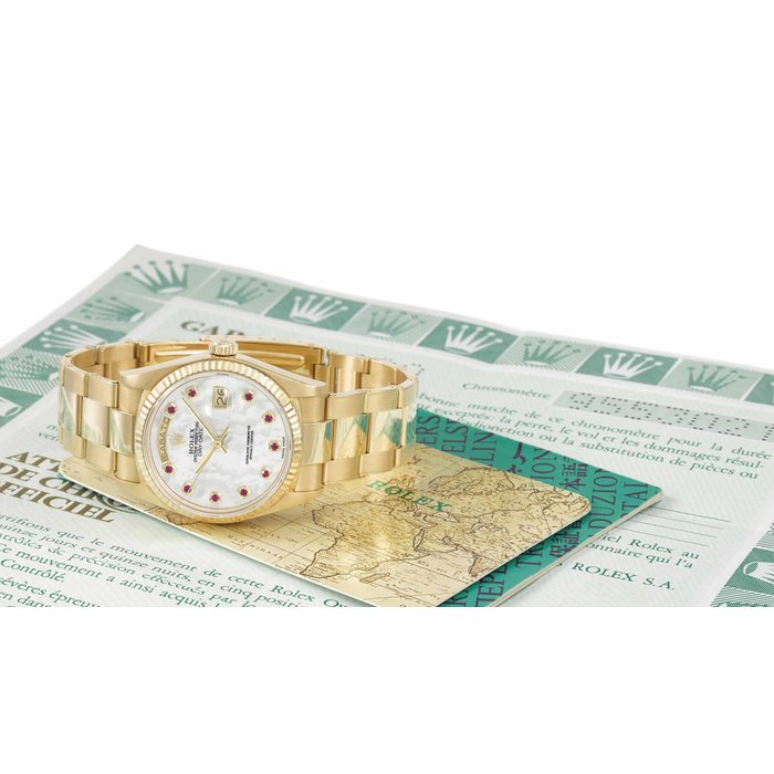 Rolex. An extremely rare and very attractive 18K gold and ruby-set automatic wristwatch with sweep centre seconds, day, date, mother-of-pearl dial, bracelet and Garantie Signed Rolex, Oyster Perpetual, Day-date, ref. 18038, case no. 9’553’821, circa 1986