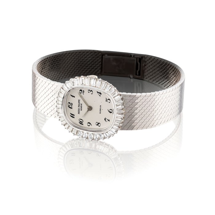 PATEK PHILIPPE. A LADY ’ S FINE AND ELEGANT 18K WHITE GOLD AND DIAMOND-SET OVAL BRACELET WATCH WITH BREGUET NUMERALS SIGNED PATEK PHILIPPE, GENEVE, RETAILED BY GUBELIN, REF. 4138/1, MOVEMENT NO. 1’260’345 CASE NO. 2’714’939, MANUFACTURED IN 1971