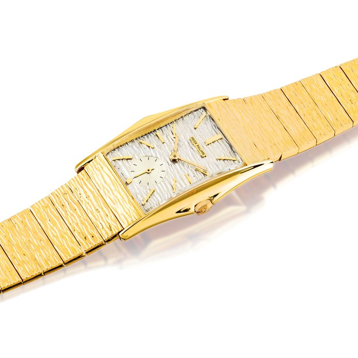 PATEK PHILIPPE. A FINE AND VERY RARE 18K GOLD RECTANGULAR BRACELET WATCH WITH FLARED SIDES SIGNED PATEK PHILIPPE, GENEVE, REF. 2554/7, MOVEMENT NO. 977’538 CASE NO. 2’615’127 MANUFACTURED IN 1961