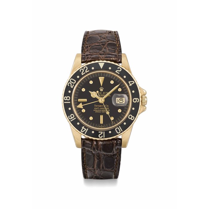 Rolex. A fine and extremely rare, 18K gold automatic two time-zone wristwatch with sweep centre seconds, black nipple dial, 24 hour bezel, date and confirmation of sale letter from Tiffany & Co., New York Signed Rolex, retailed by Tiffany & Co., Oyster Perpetual, GMT-Master, Superlative Chronometer Officially Certified, ref. 1675, case no. 5’662’260, manufactured in 1978