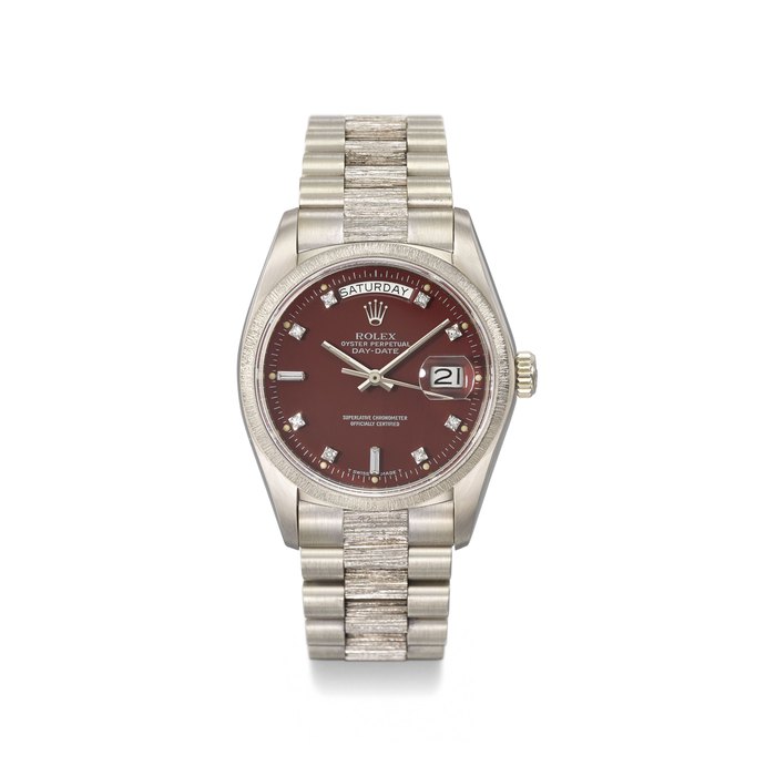 ROLEX. A VERY FINE, RARE AND ATTRACTIVE 18K WHITE GOLD AUTOMATIC WRISTWATCH WITH SWEEP CENTRE SECONDS, DAY, DATE, BURGUNDY RED LACQUER AND DIAMOND-SET STELLA DIAL, BRACELET, INTERNATIONAL GUARANTEE AND BOX SIGNED ROLEX, OYSTER PERPETUAL, DAY-DATE, REF. 18079, CASE NO. 5’288’251, CIRCA 1978