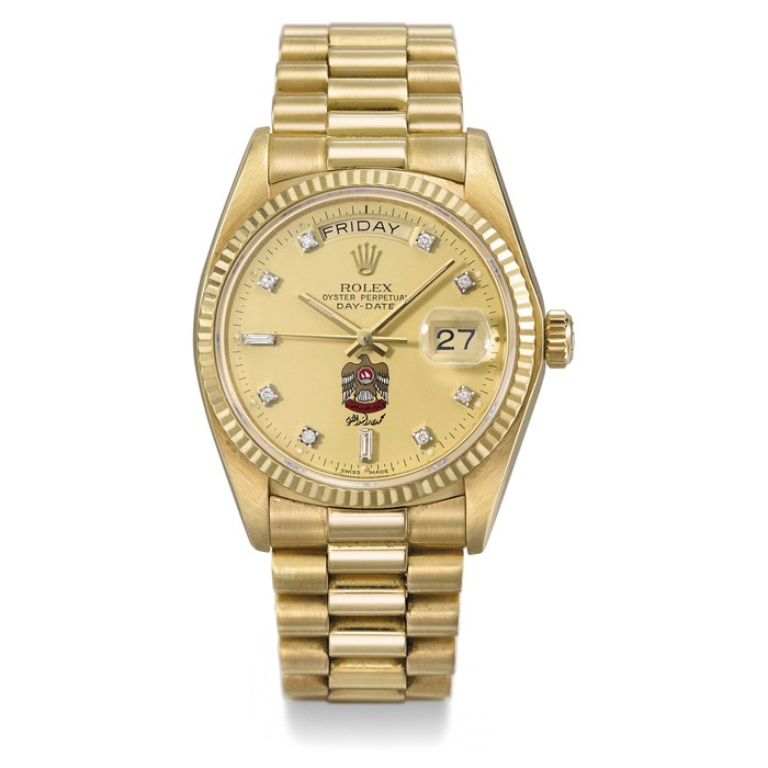 ROLEX. A RARE 18K GOLD AUTOMATIC WRISTWATCH WITH SWEEP CENTRE SECONDS, DAY, DATE, UAE CREST AND THE SIGNATURE OF HIS HIGHNESS SHEIKH MOHAMMED BIN RASHID AL MAKTOUM AND BRACELET SIGNED ROLEX, OYSTER PERPETUAL, DAY-DATE, REF. 18038, CASE NO.6’375’118, CIRCA 1980