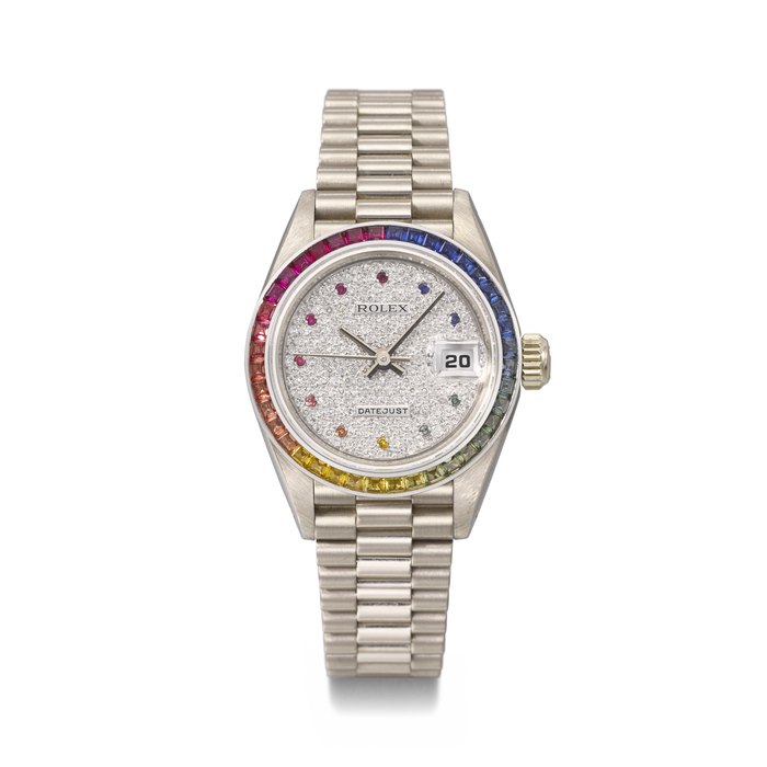 ROLEX. AN EXTREMELY RARE AND ATTRACTIVE 18K WHITE GOLD, DIAMOND AND MULTICOLOURED SAPPHIRE-SET AUTOMATIC WRISTWATCH WITH SWEEP CENTRE SECONDS, DATE, BRACELET AND GUARANTEE SIGNED ROLEX, DATEJUST 'RAINBOW' MODEL, REF. 69119, CASE NO. 9'091'464, CIRCA 1986