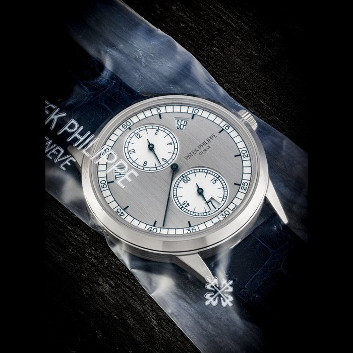 PATEK PHILIPPE. AN 18K WHITE GOLD AUTOMATIC ANNUAL CALENDAR WRISTWATCH WITH REGULATOR-STYLE DIAL, SINGLE SEALED REF. 5235G-001, CIRCA 2014