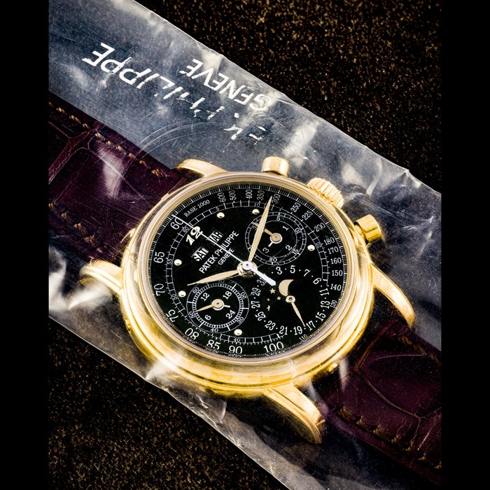 PATEK PHILIPPE. AN EXTREMELY RARE 18K GOLD PERPETUAL CALENDAR CHRONOGRAPH WRISTWATCH WITH MOON PHASES, 24 HOUR, LEAP YEAR INDICATION AND BLACK DIAL WITH BREGUET NUMERAL AND TACHYMETER SCALE, SINGLE SEALED REF. 3970EJ-029, CIRCA 2009