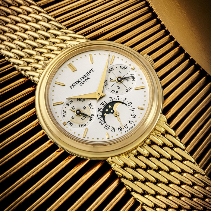 PATEK PHILIPPE. AN 18K GOLD AUTOMATIC PERPETUAL CALENDAR WRISTWATCH WITH LEAP YEAR, MOON PHASES INDICATION AND BRACELET REF. 3945/1, CIRCA 1991