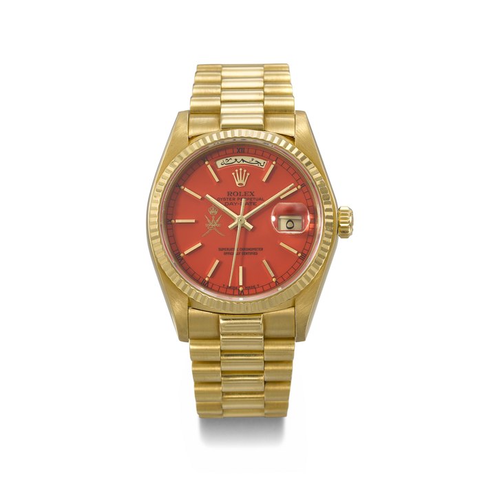 ROLEX. AN EXTREMELY RARE AND HIGHLY ATTRACTIVE 18K GOLD AUTOMATIC WRISTWATCH WITH SWEEP CENTRE SECONDS, ARABIC CALENDAR, RED LACQUERED 'STELLA' DIAL AND BRACELET, MADE FOR THE SULTANATE OF OMAN SIGNED ROLEX, DAY-DATE MODEL, REF. 18038, CASE NO. 6'309'617, CIRCA 1979
