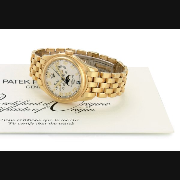 PATEK PHILIPPE. AN 18K GOLD AUTOMATIC ANNUAL CALENDAR WRISTWATCH WITH POWER RESERVE, MOON PHASES AND BRACELET SIGNED PATEK PHILIPPE, GENEVE, MOVEMENT NO. 3288440, CASE NO. 4230079, REF. 5036/1, MANUFACTURED IN 2003