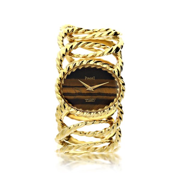 Piaget REFERENCE 9855 D35 RETAILED BY VAN CLEEF & ARPELS: A YELLOW GOLD CUFF WATCH WITH TIGER'S EYE DIAL, CIRCA 1970