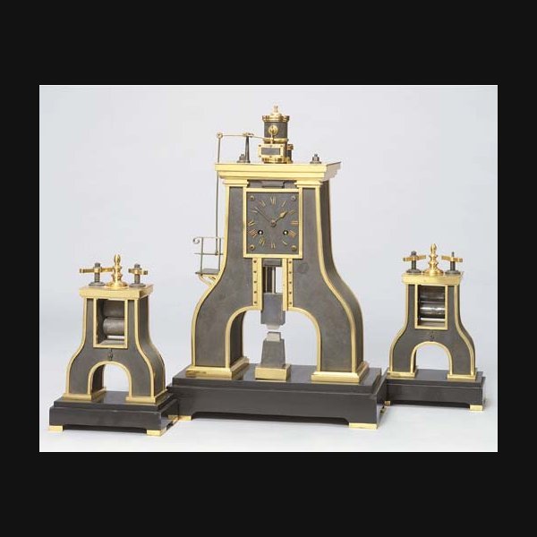 A French Gilt A French gilt, silvered and patinated brass, patinated metal and marmo nero Belgio novelty striking mantel clock in the form of an industrial steam hammer, with garniture GUILMET, MOVEMENT BY JAPY FRÈRES, NO. 417. CIRCA 1885