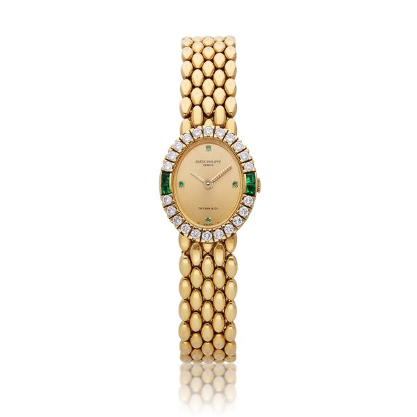 Patek Philippe Reference 4752/23 | Retailed by Tiffany & Co.: A yellow gold, diamond and emerald-set bracelet watch, Circa 1980