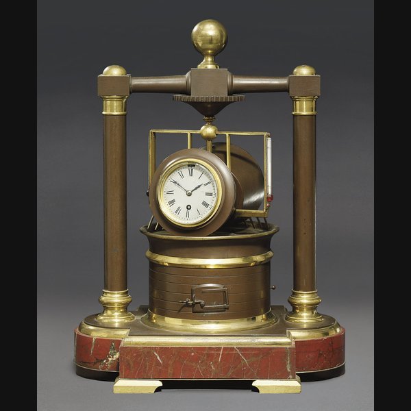  A French brass and patinated brass and red marble eight day timepiece in the form of an ore roller with barometer, twin thermometers and automaton dials CIRCA 1890
