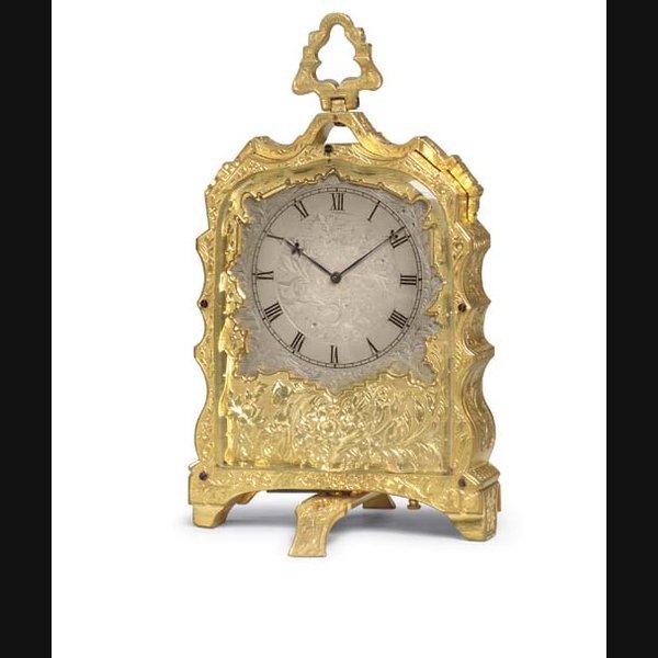 A Victorian engraved gilt-brass desk timepiece IN THE STYLE OF THOMAS COLE, RETAILED BY PHILLIPS BROTHERS, LONDON. CIRCA 1860