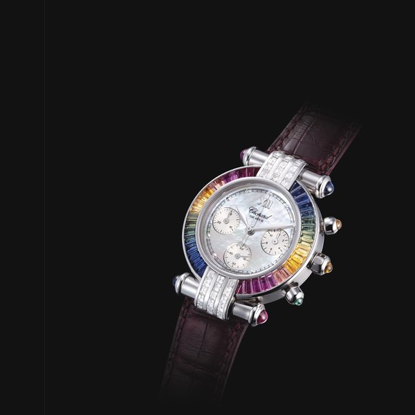 CHOPARD. A LADY'S FINE 18K WHITE GOLD AND MULTI-COLOURED GEM-SET CHRONOGRAPH WRISTWATCH WITH MOTHER-OF-PEARL DIAL SIGNED CHOPARD, CASE NOS. 702'613 AND 4143, CIRCA 2000