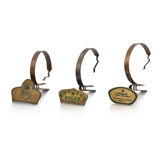 Rolex A set of three gilt brass and green enamel watch stands, Circa 1950 | 勞力士 | 一套三件鍍金銅製鑲綠琺瑯展示座，約1950年